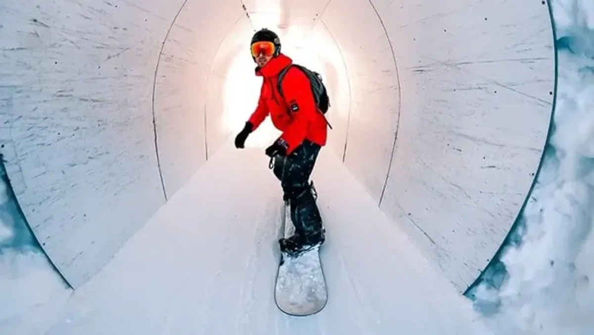 Snowboarder performing stunts in a snowy tunnel