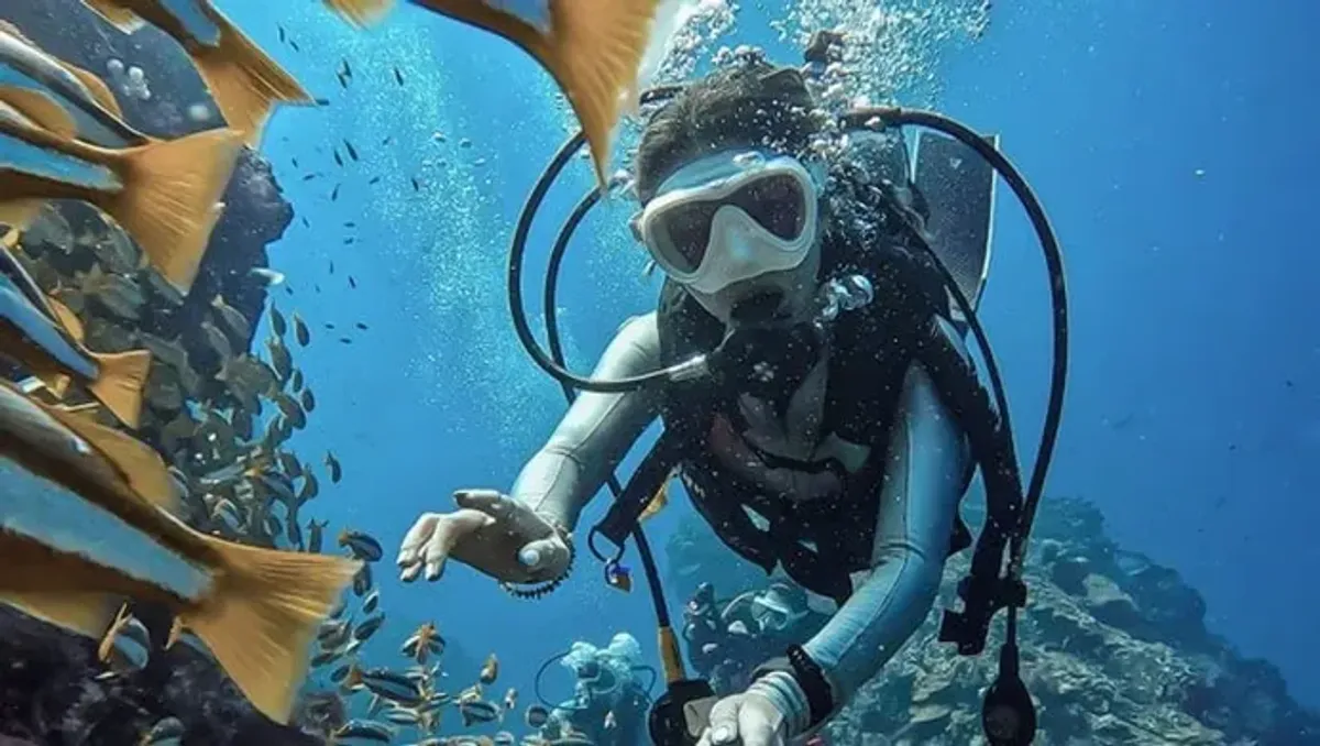 Scuba diver filming underwater with GoPro equipment