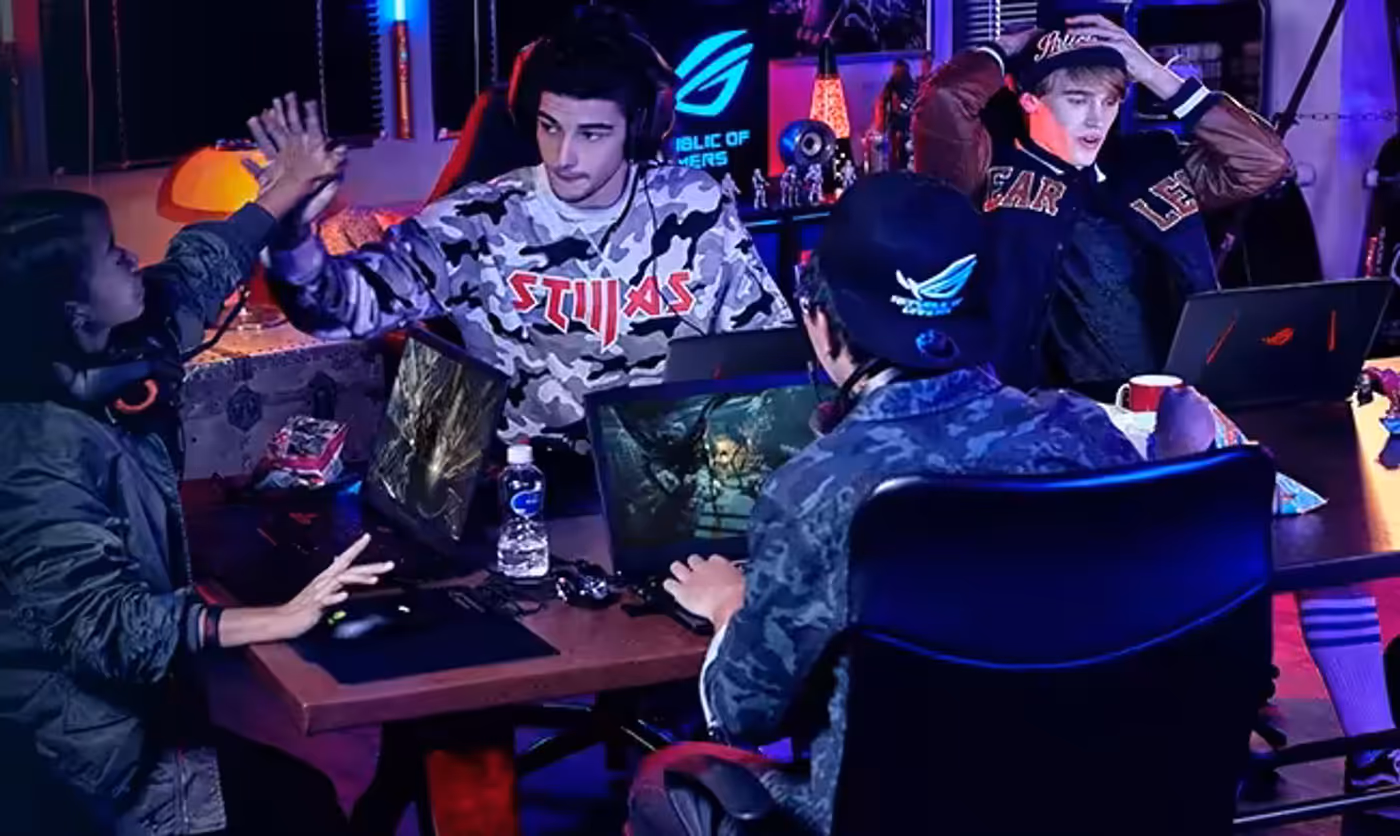 Four young adults gaming together in a room featuring ROG high-performance networking equipment.