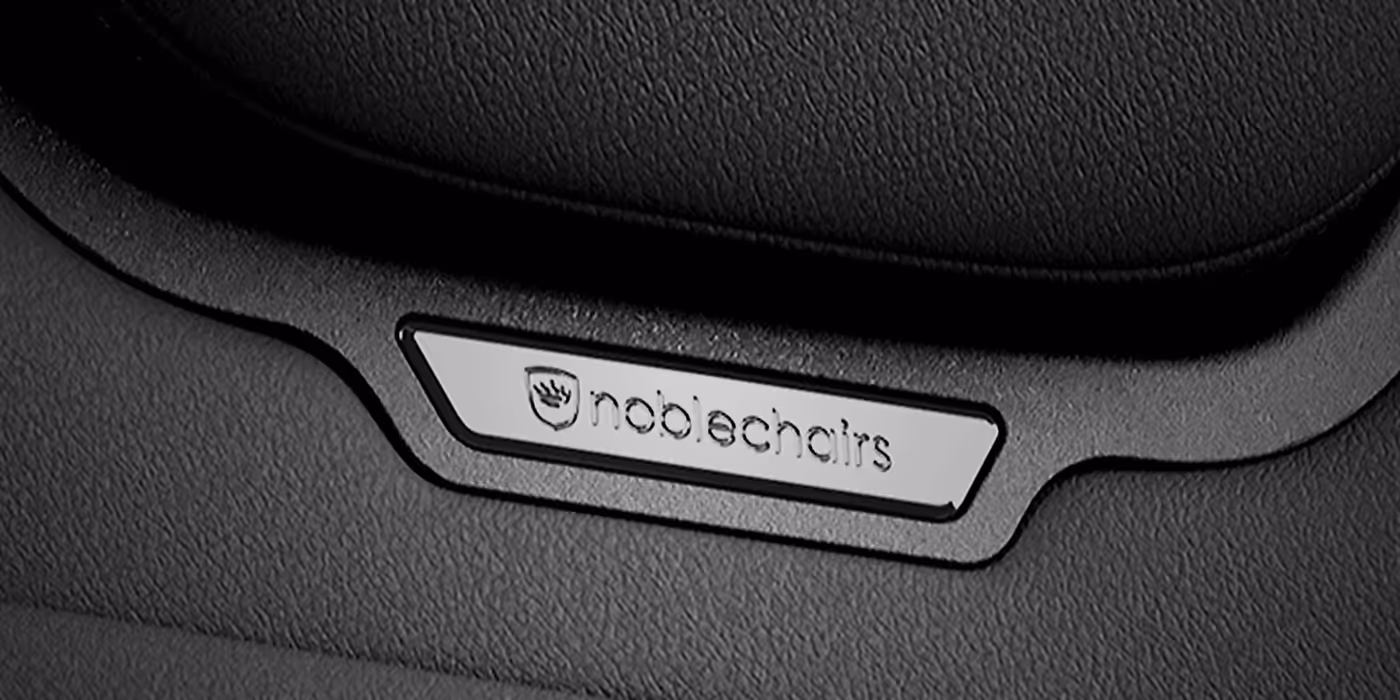 Detail view of the premium magnetic metal emblem on the AURA chair