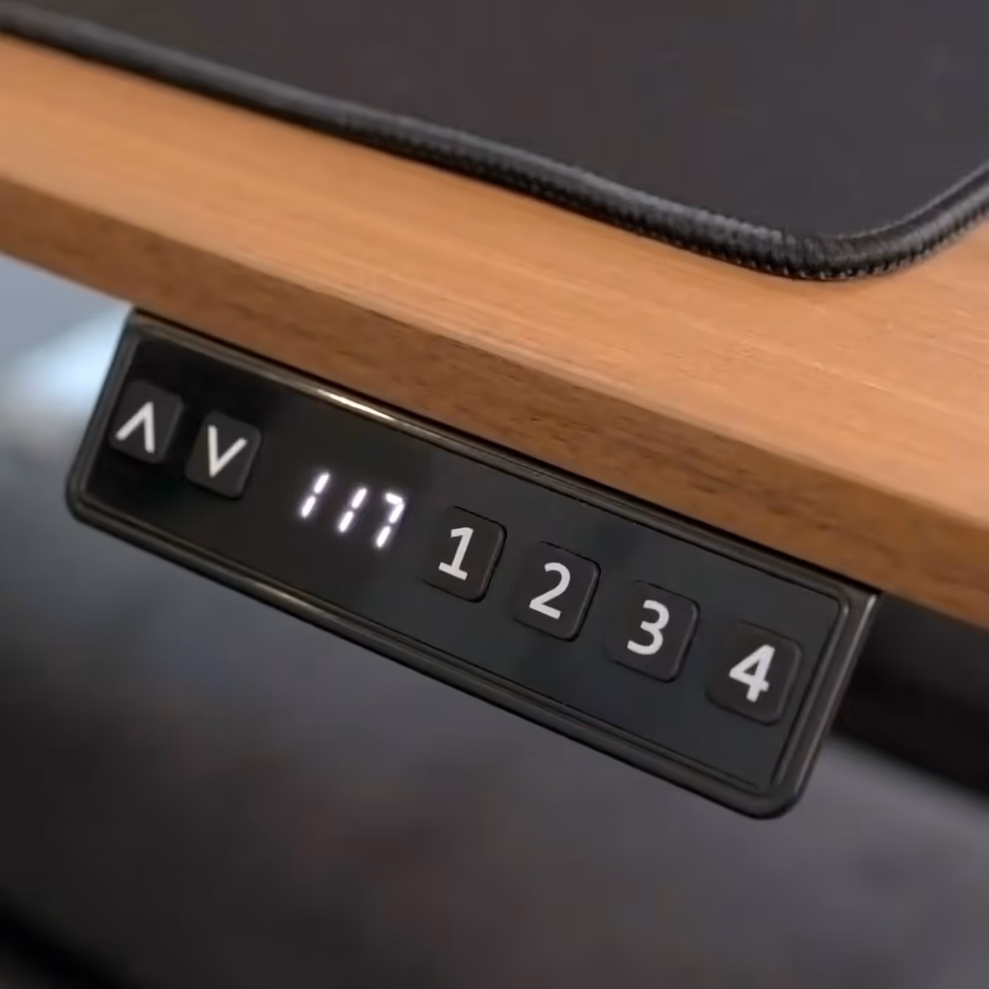 User adjusting the motorized desk height using the LED control panel