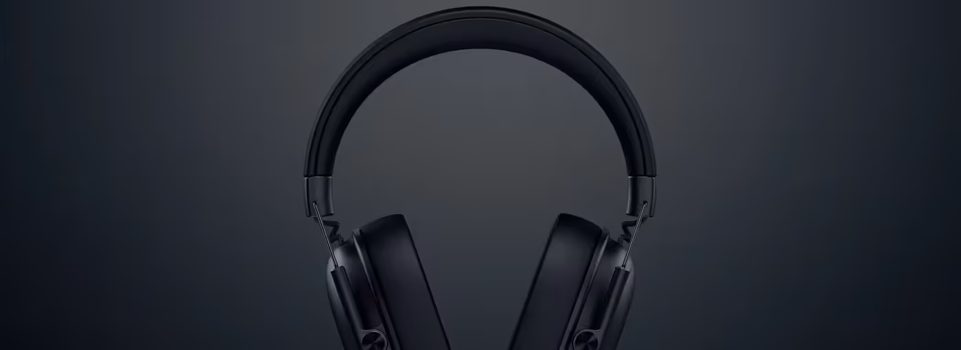 Wireless black headphones with a sleek design, set against a dark gray background.