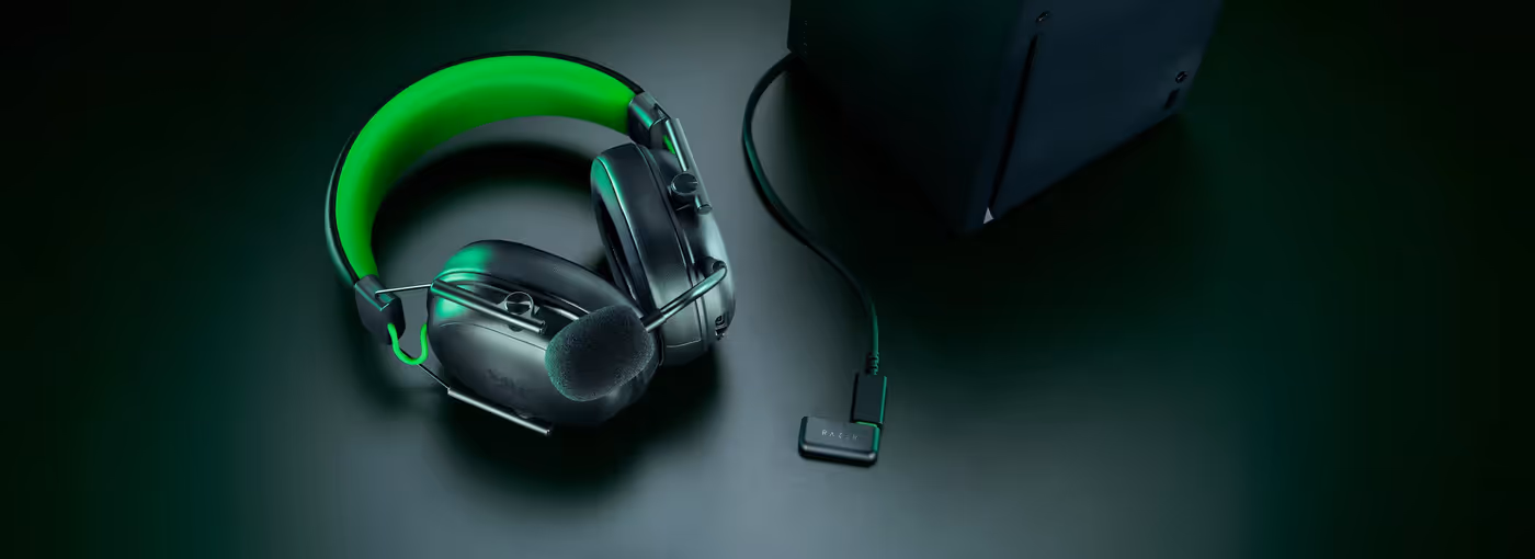 Black gaming headset with microphone and green accents shown in a three-mode connectivity setup