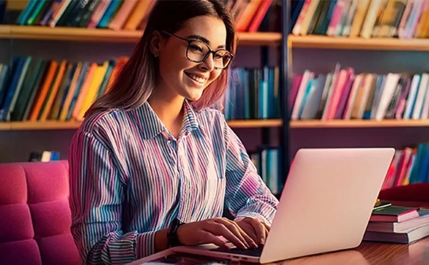 Woman using laptop with Crucial BX500 for storing photos, music, and video files