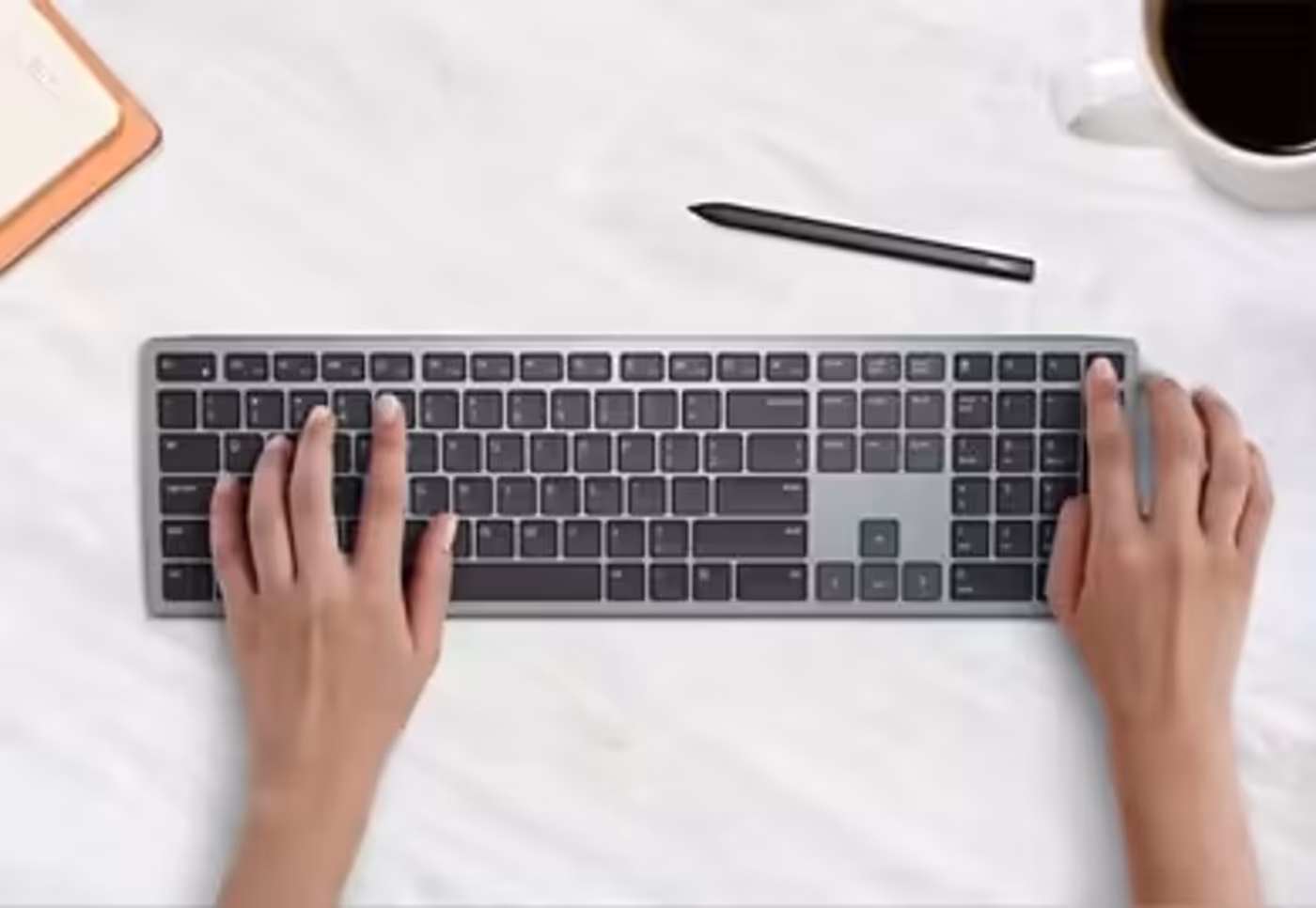 Close-up of hands typing on the Dell Multi-Device Wireless Keyboard KB700