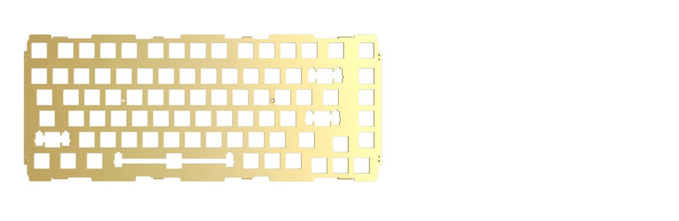 Brass switch plate laid flat, showing the 83 key cut-outs and the stabiliser slots
