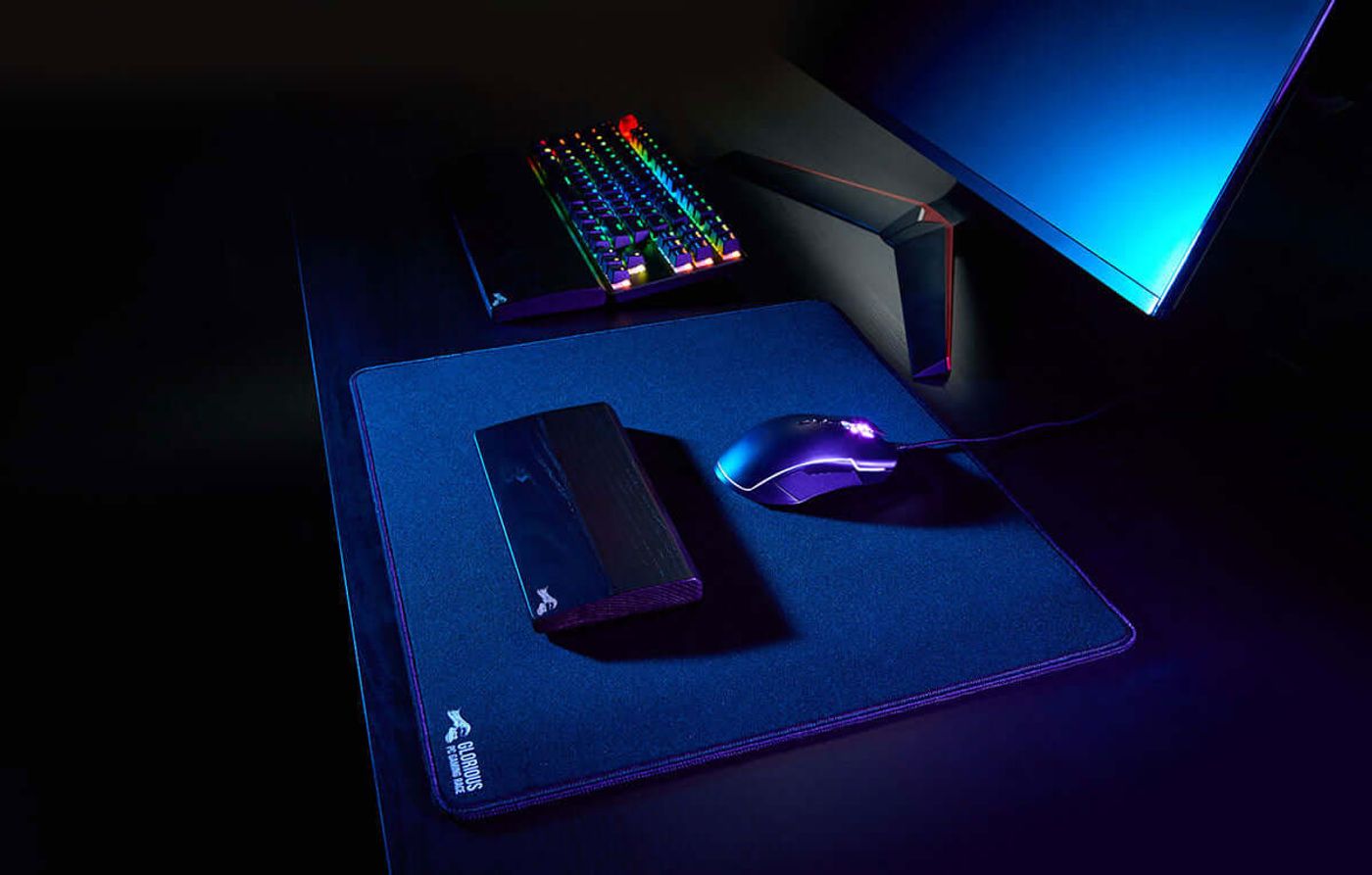 Glorious wooden mouse wrist rest in an Onyx finish shown beside a gaming mouse