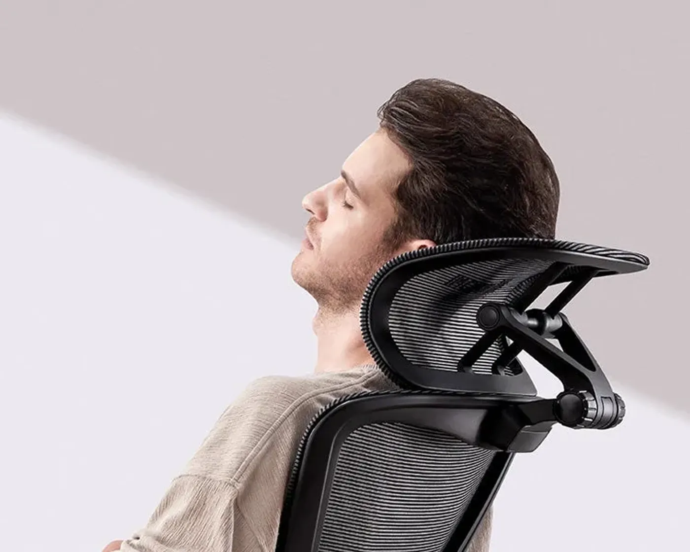 Man sitting upright with head supported by the curved side of the 3D adjustable headrest