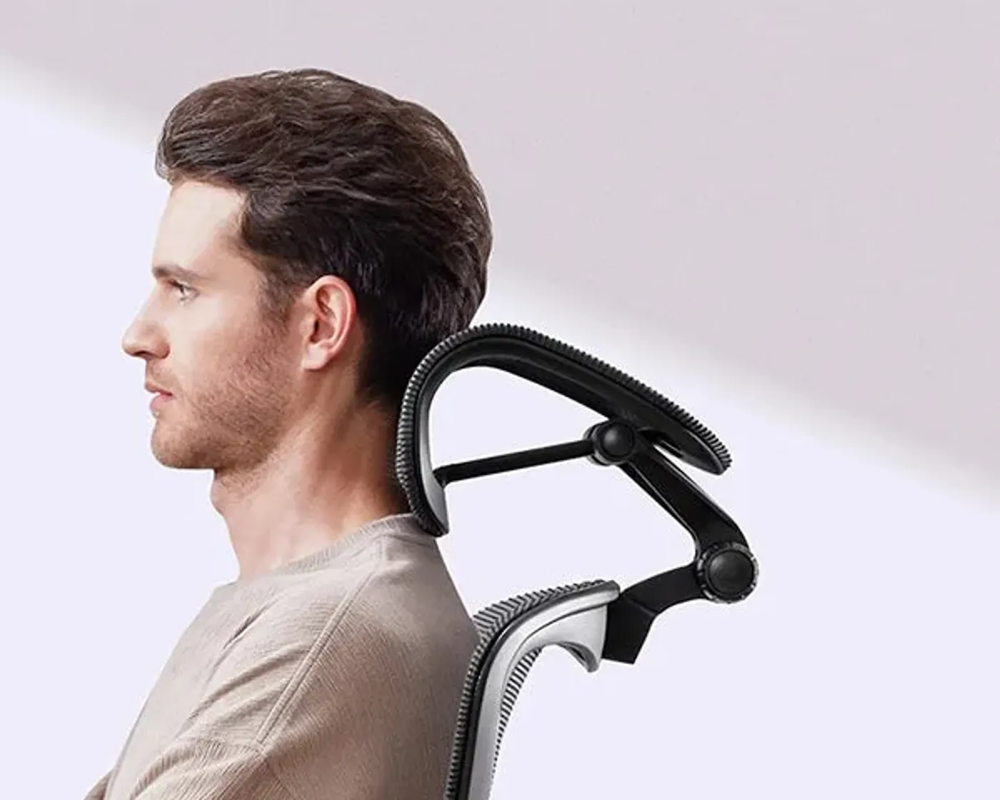 Man sitting upright with head supported by the curved side of the 3D adjustable headrest