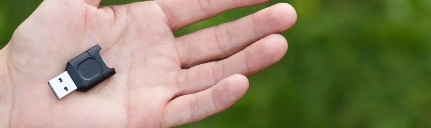 Kingston MobileLite Plus card reader held in a hand, showing how small the body is