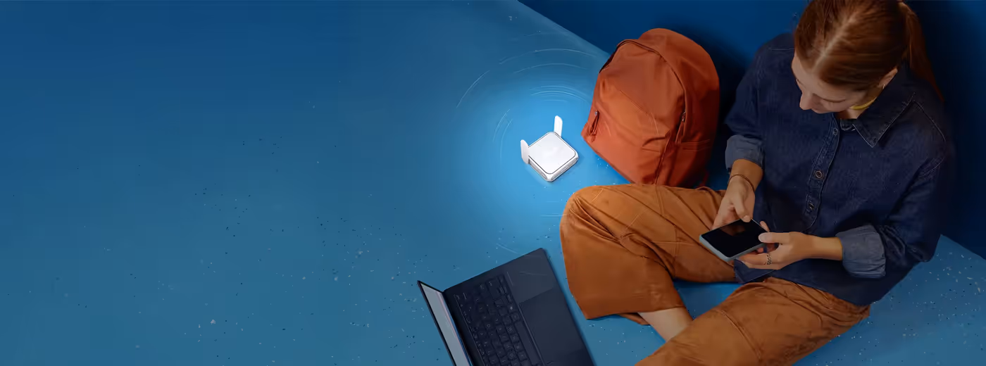 User with laptop and smartphone using the ASUS RT-BE58 Go portable WiFi 7 travel router