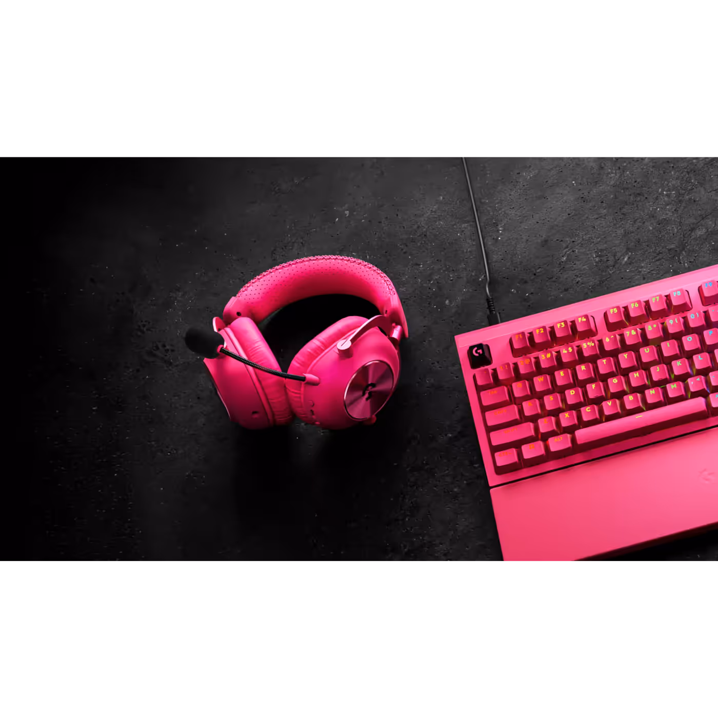 PRO X3 LIGHTSPEED in magenta on a desk next to a keyboard