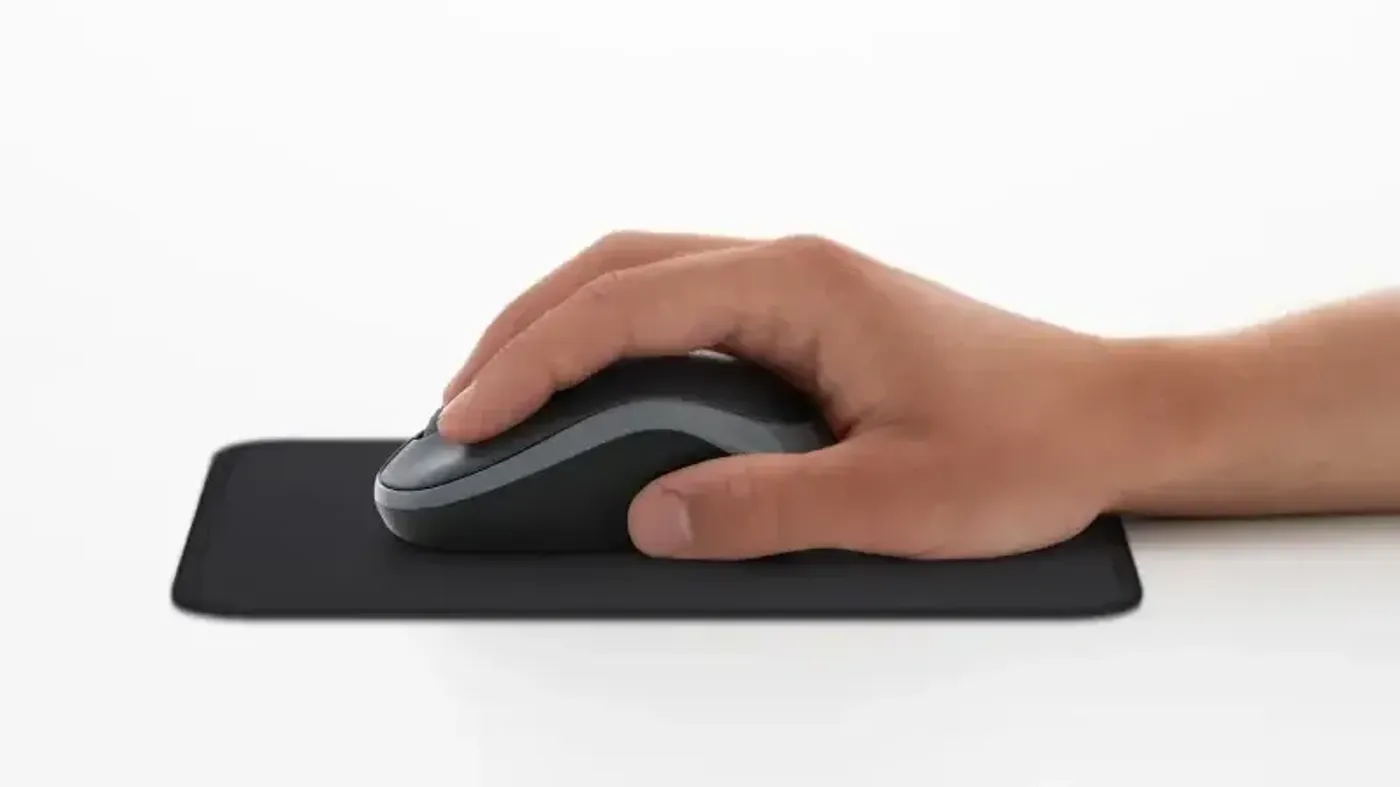 Contoured shape of the Logitech M185 wireless mouse held in the hand
