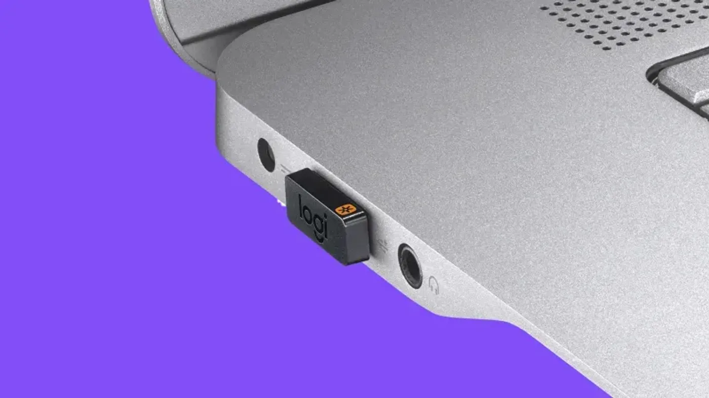 Compact Logitech Unifying receiver sitting almost flush in a laptop USB port