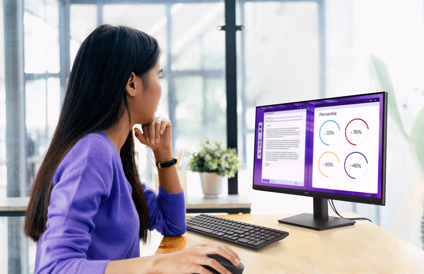 An office worker using a Dell Pro 24 Monitor connected to a Dell laptop.