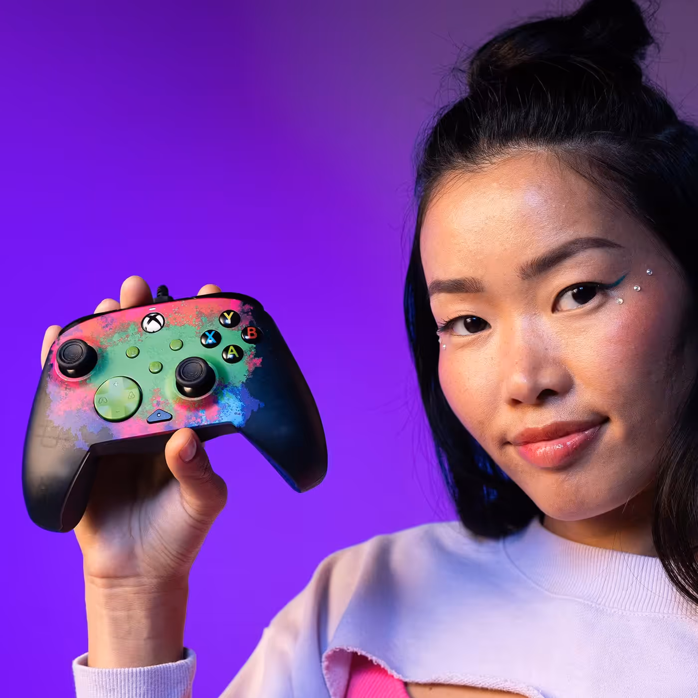 Person holding the PDP REMATCH GLOW Space Dust controller