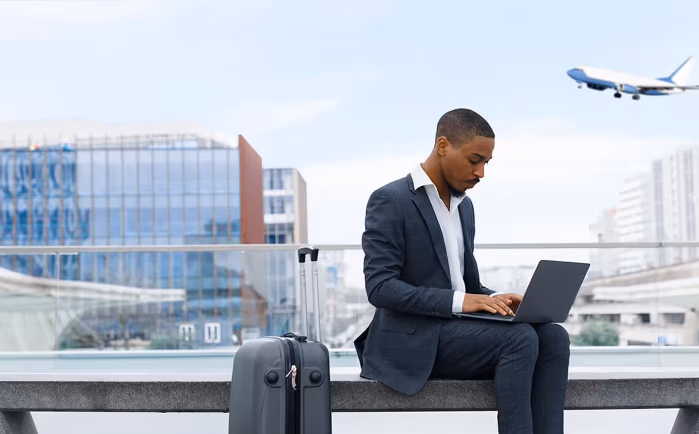 A businessman working on a laptop in a terminal, demonstrating secure public WiFi usage