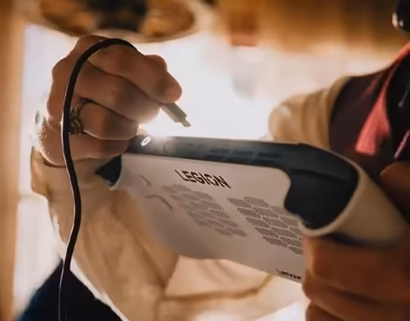 Person plugging a cable into the top port of Lenovo Legion Go S Gen 1 (8") handheld.