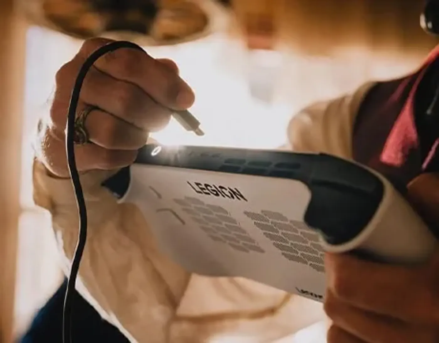 Person plugging a cable into the top port of Lenovo Legion Go S Gen 1 (8") handheld.