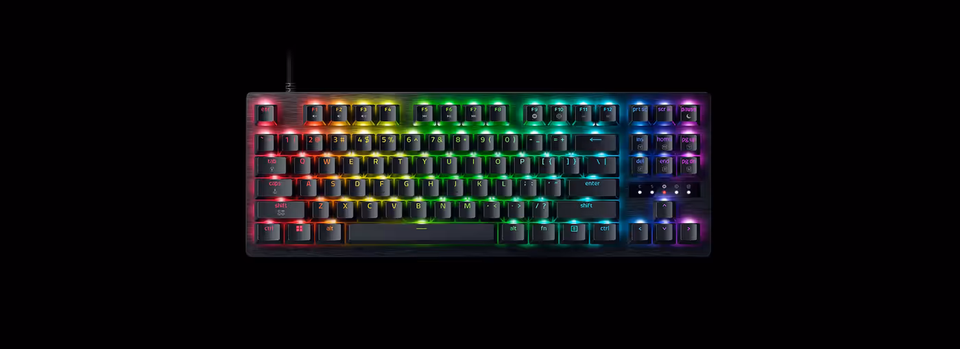 RGB backlit mechanical keyboard with colored keys, including functions keys, arrow keys, and a numeric keypad on black background.