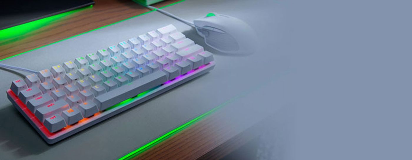 Razer Huntsman Mini next to a mouse showing how little desk space it uses