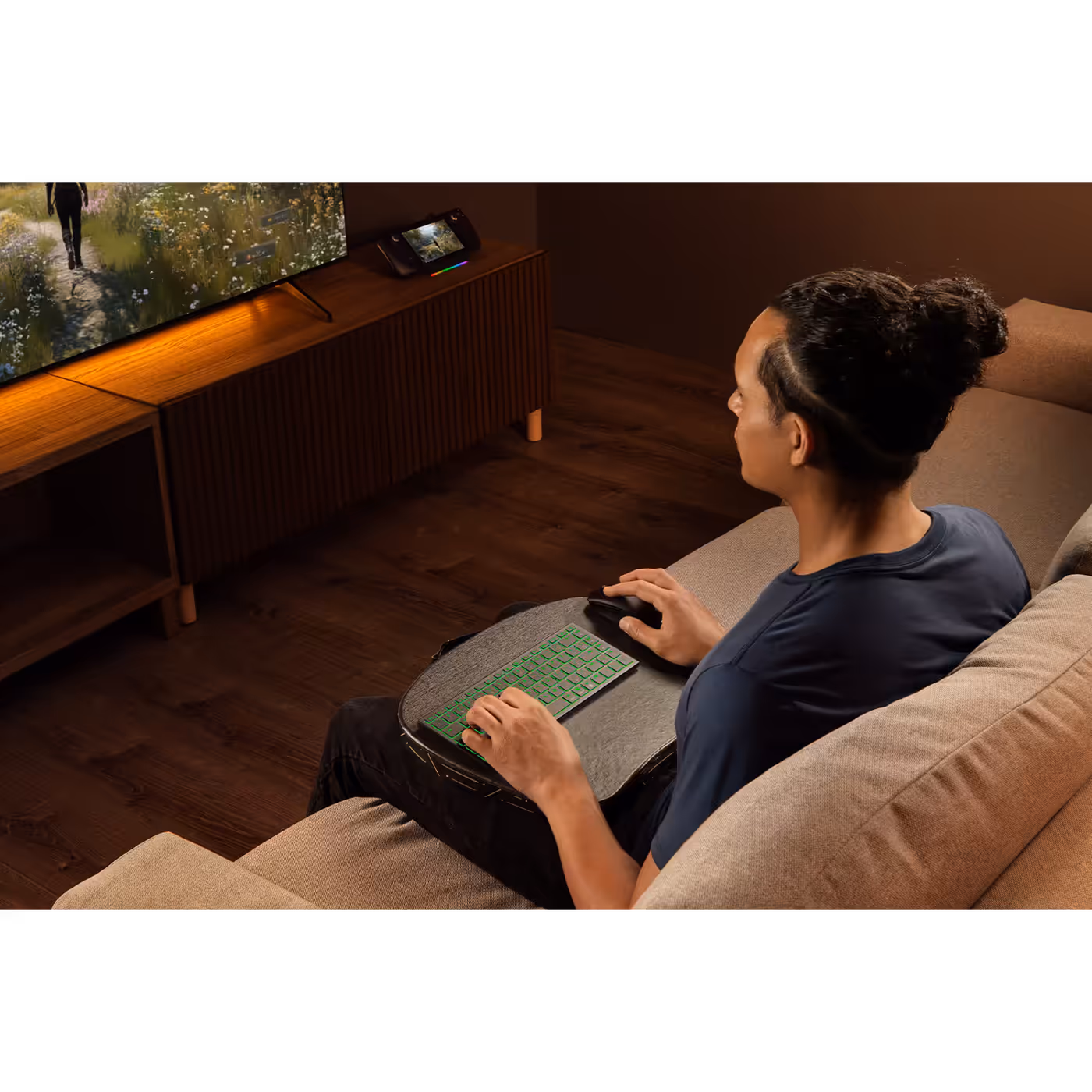 Person using the Razer Joro on their lap on a couch in front of a TV