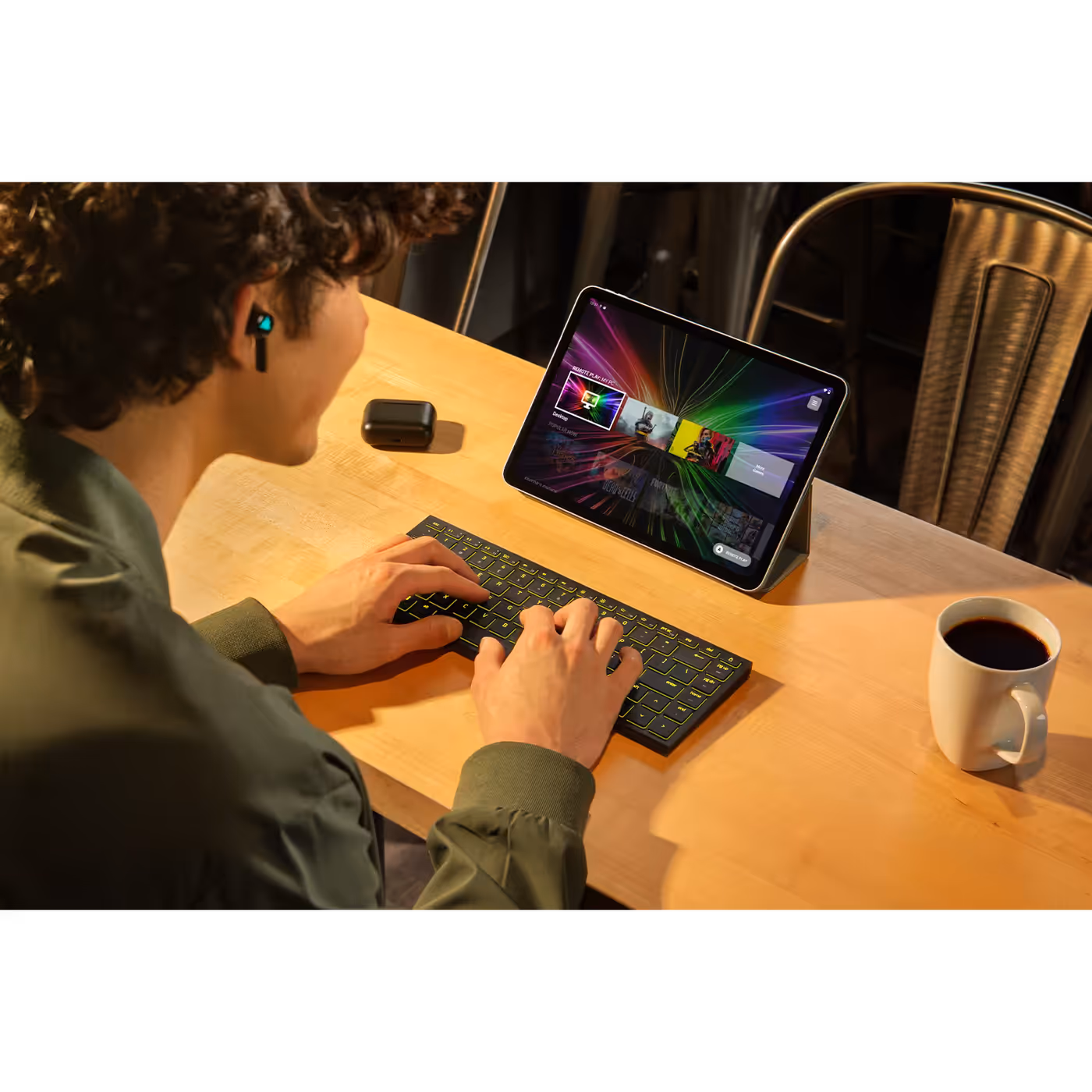 Person typing on the Razer Joro in front of an iPad on a cafe table