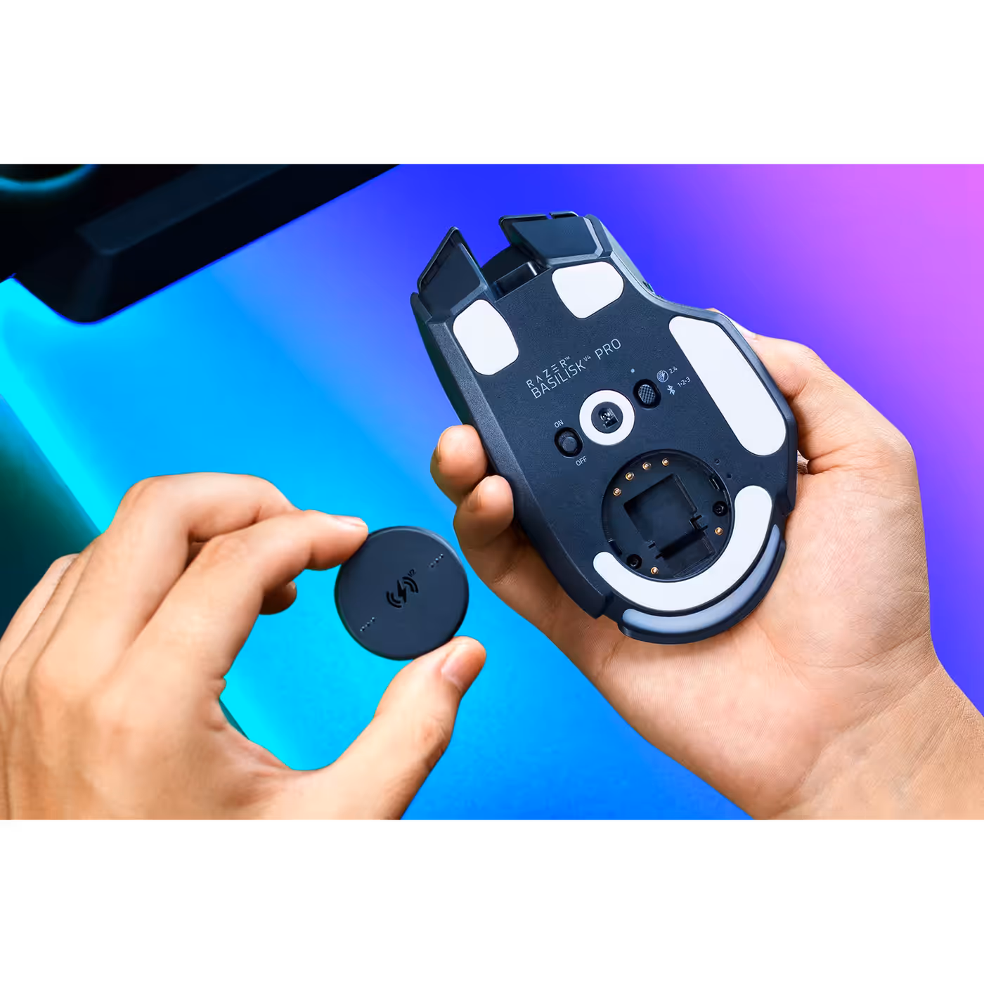 Hands fitting the Razer Wireless Charging Puck V2 to the underside of a mouse