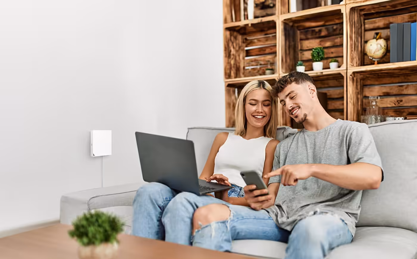 A couple using internet devices at home, highlighting stable connectivity for daily living