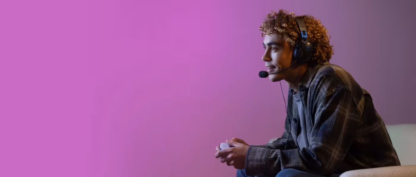 Young gamer wearing Turtle Beach headset gaming against a purple background