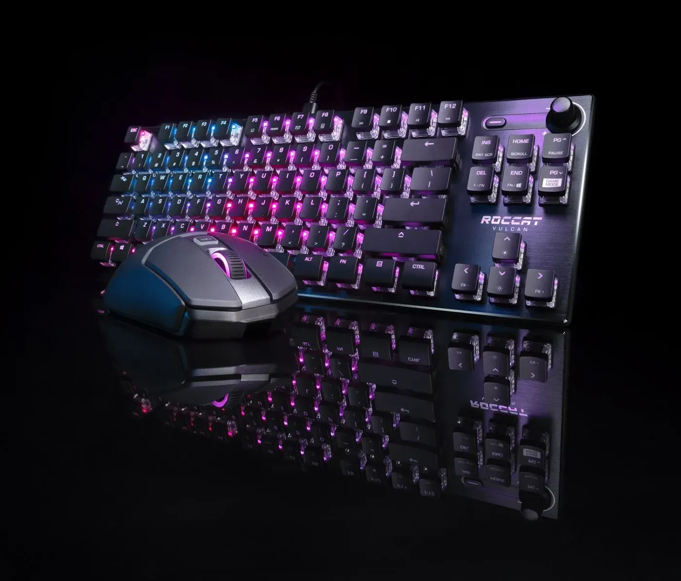 Gaming keyboard and mouse reflecting colorful RGB lighting on a dark surface