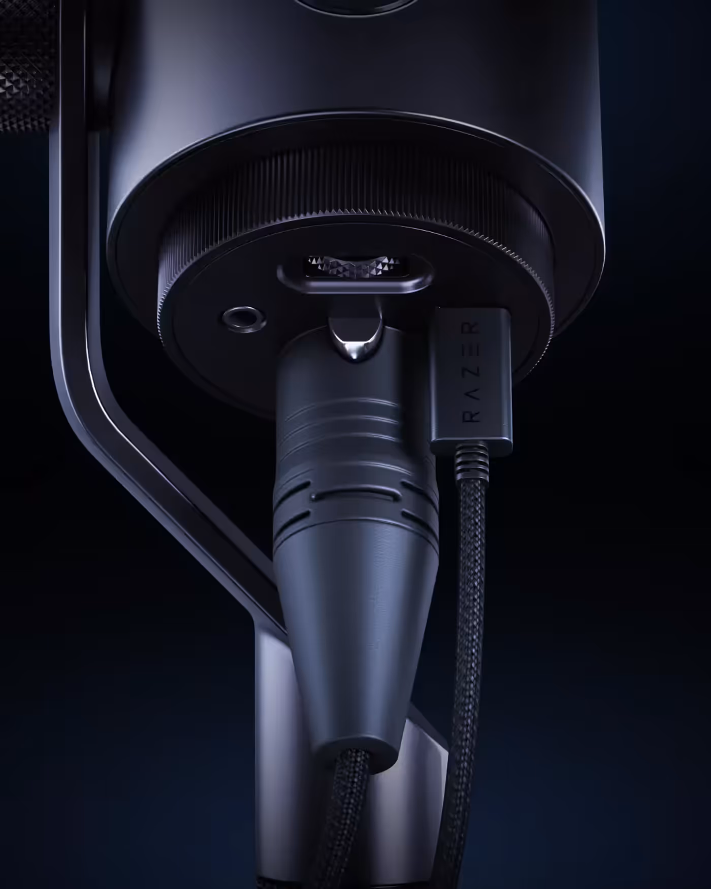 Close-up of a sleek, black Razer gaming microphone on a stand, with braided cable and minimalistic design against a dark background.