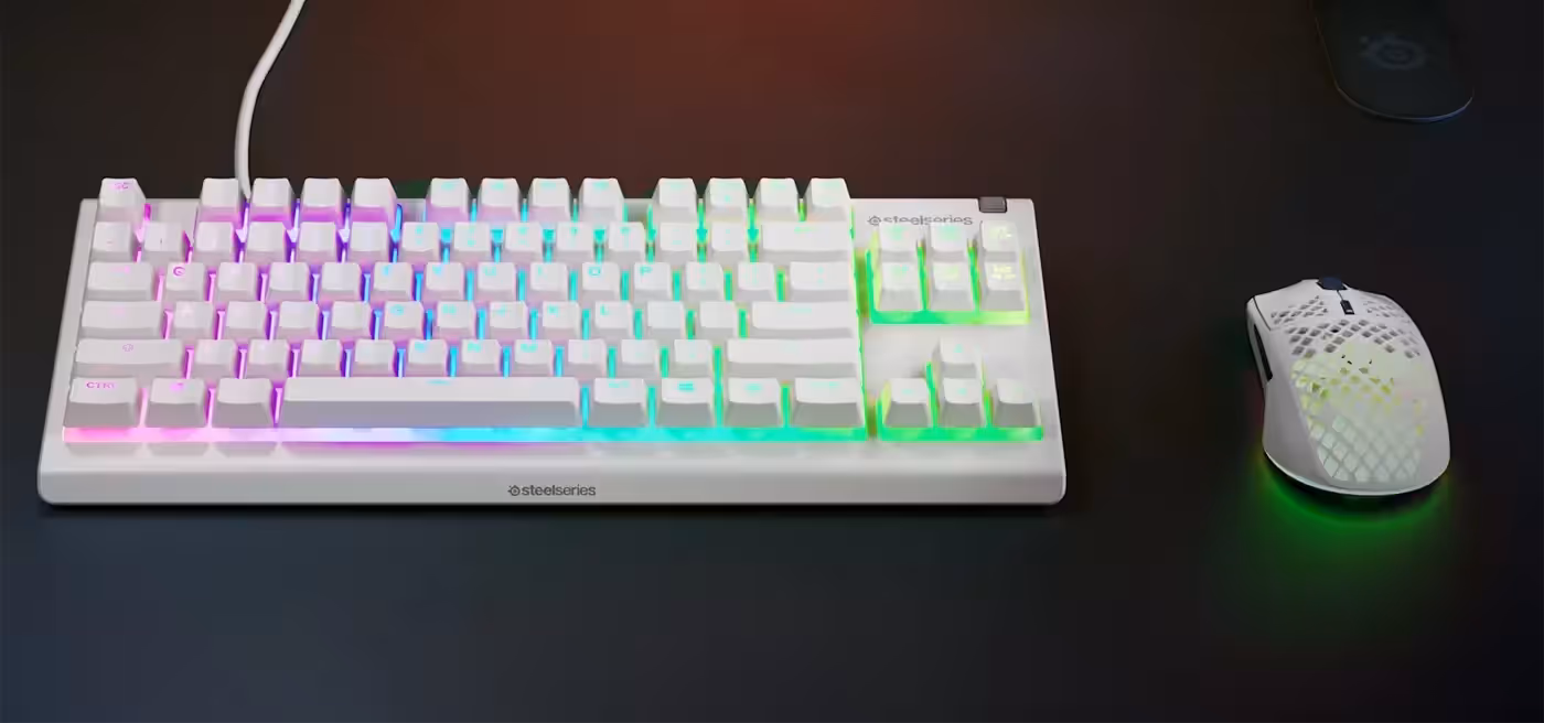 Top-down view of the Apex 3 TKL white keyboard beside a mouse showing the space saved by the tenkeyless layout