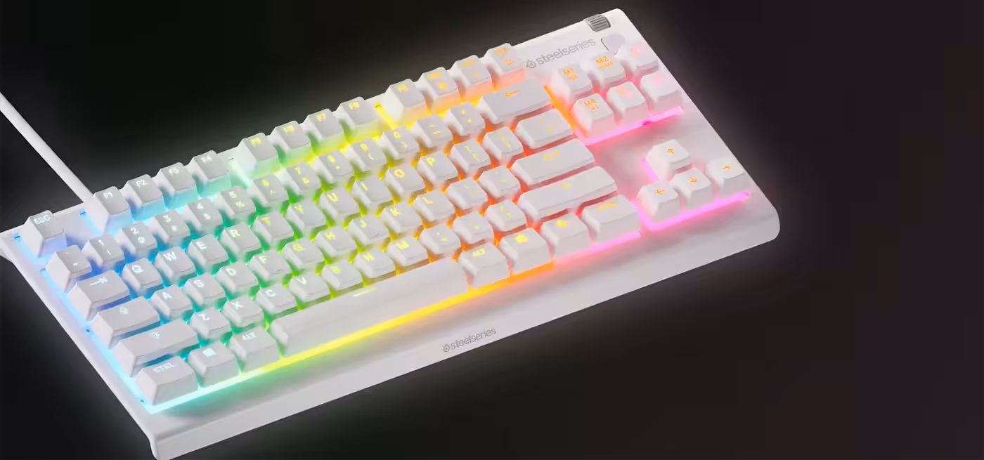 PrismSync 8-zone RGB lighting glowing across the white Apex 3 TKL keyboard in a dark room