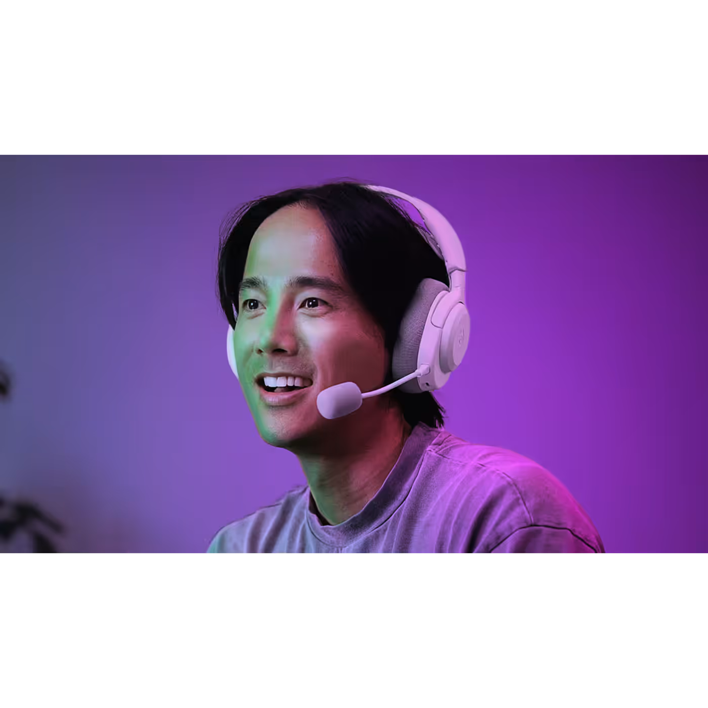 A gamer wearing the SteelSeries Arctis Nova 3 Wireless in White with the mic extended