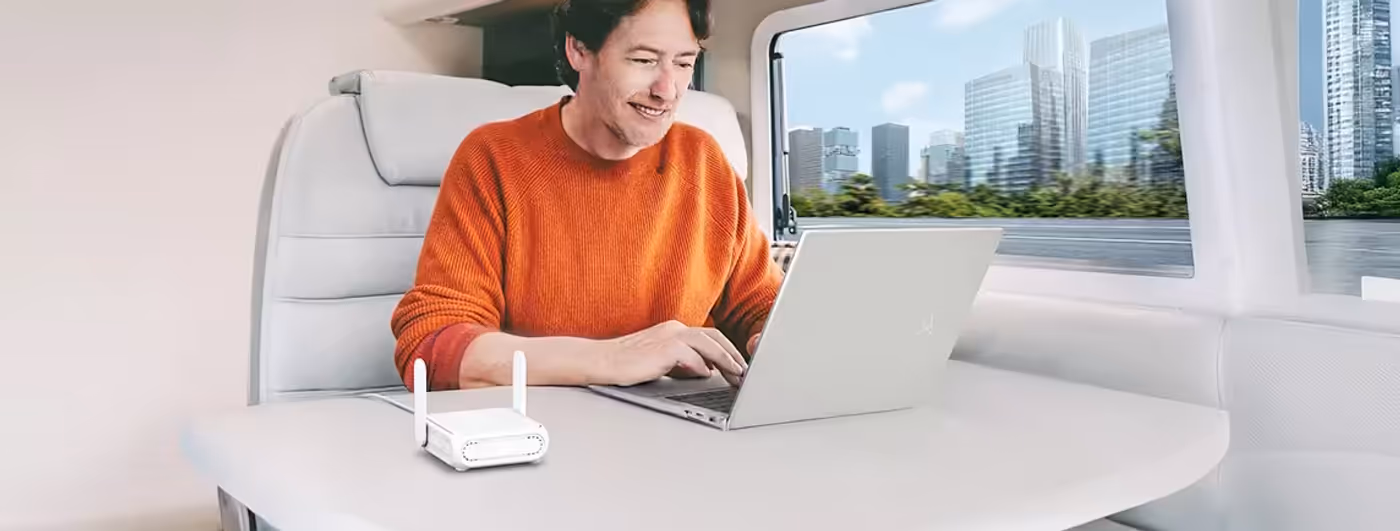 ASUS RT-BE58 Go router on a table providing portable WiFi for a laptop user