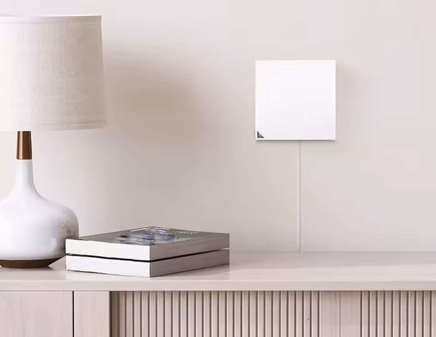 The RT-AX57 Go device wall-mounted discreetly behind a cabinet.